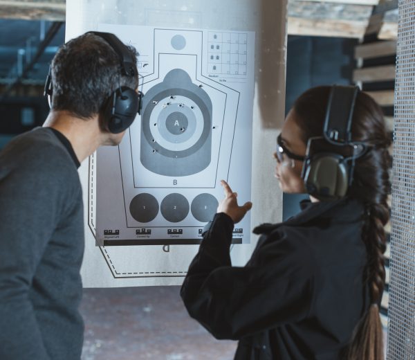shooting-instructor-pointing-on-used-target-in-shooting-range.jpg